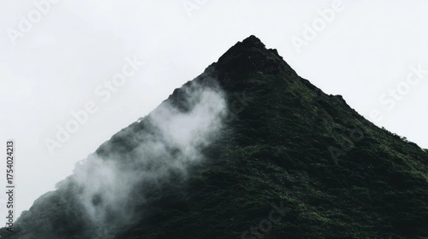 Obraz A rugged volcanic peak towers with dense green vegetation,