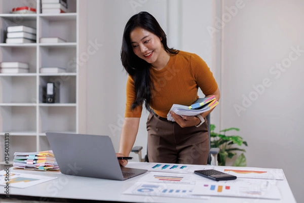Fototapeta Business woman hands of paper files for searching and checking on laptop unfinished document archives on folders papers at busy work desk office