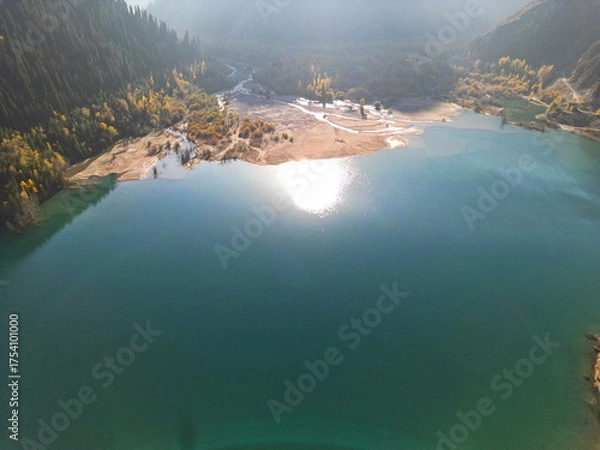 Fototapeta Lake Issyk in the rays of the setting sun. National Nature Park. Mountainous area with different vegetation.