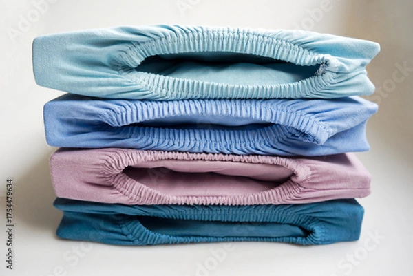 Obraz Brand new stapled fitted sheets in different colors against white background. Photo taken October 14th, 2025, Zurich, Switzerland.