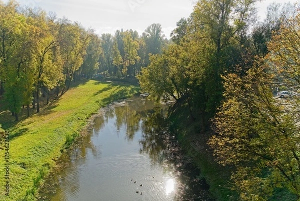Fototapeta  Vitebsk, Belarus, October 8, 2025. View of an autumn park from a bridge.                              
