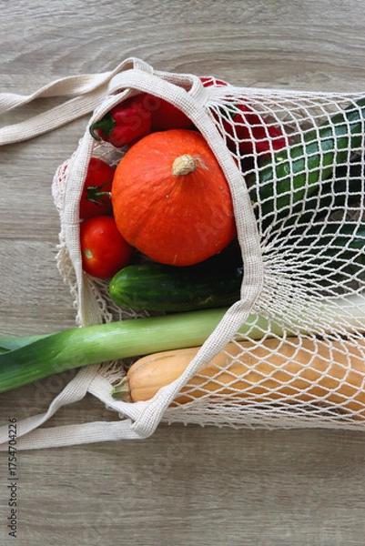 Obraz Mesh bag with various healthy vegetables on wooden background.
