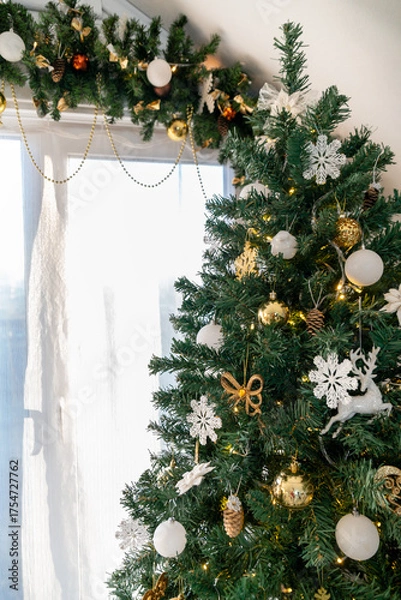 Fototapeta Christmas tree in the interior of a bright living room. The attic. Daytime