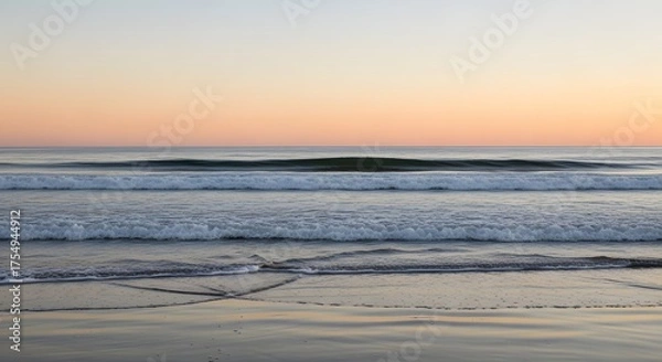 Fototapeta Serene ocean waves gently lapping on a sandy shore at sunset