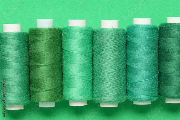 Fototapeta Spools of thread on green background
