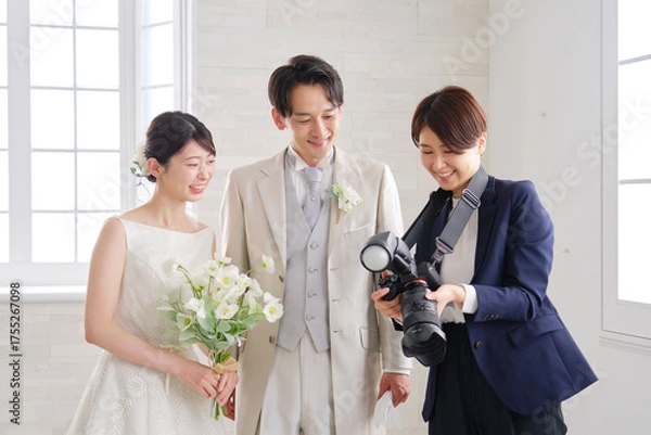 Fototapeta 笑顔で会話する新郎新婦とブライダルフォトグラファー