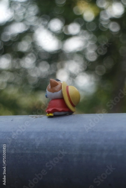 Obraz a toy cat wearing a hat is sitting in nature