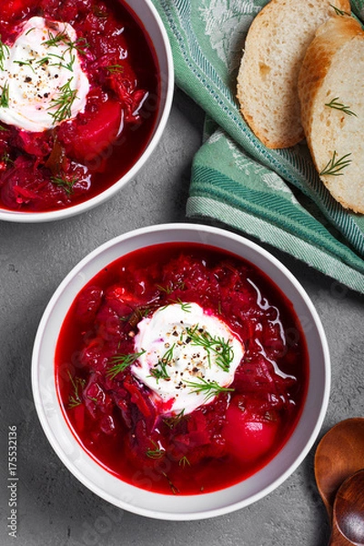 Fototapeta Red hot borch beetroot soup with sour cream. A traditional russian soup. Top view. Fall dinner and lunch. Grey background