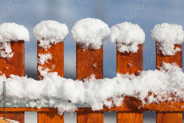Obraz detail of a new wooden garden fence covered with fresh snow in sunny weather
