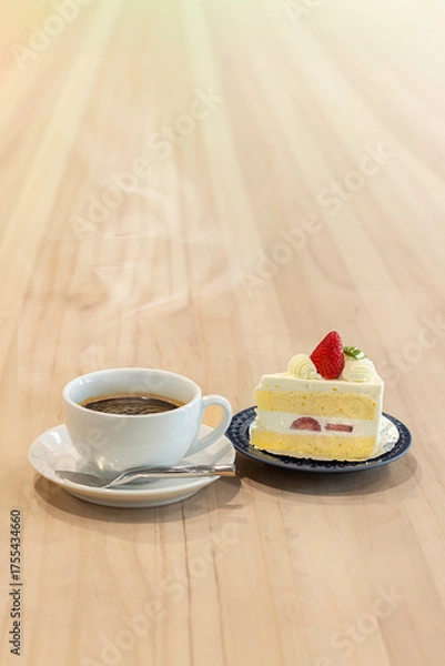 Obraz Delightful cup of coffee paired with a slice of strawberry cake on a wooden table in a cozy cafe setting