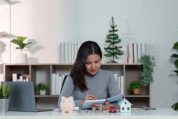 Obraz Financial Planning. Woman writing in notebook, managing savings and investments.