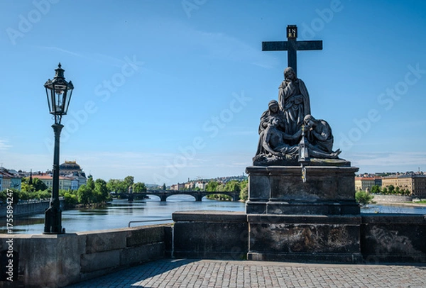 Fototapeta Statue of the Lamentation of Christ (Pietà) on Charles Bridge over the Vltava River in Prague Old Town, Czech Republic, photographed on a bright morning.