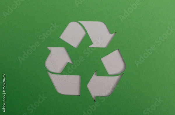Fototapeta A crisp, clean shot of a paper cutout recycling symbol against a vivid green background. Great for themes like recycling, waste management, envi