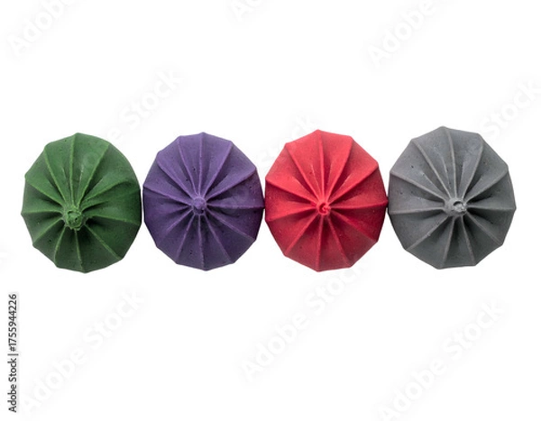 Fototapeta Four colorful, starburst-shaped objects arranged horizontally against a stark black background