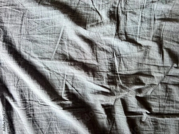 Obraz a wrinkled gray bed sheet with a ray of sunlight woman hand