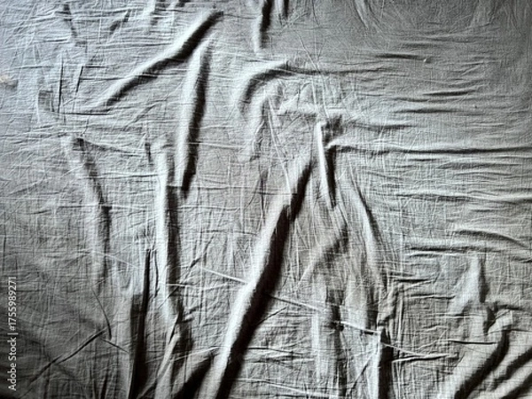 Obraz a wrinkled gray bed sheet with a ray of sunlight woman hand