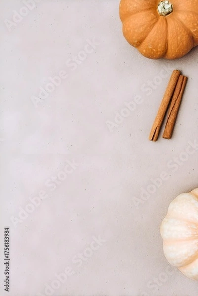 Fototapeta Minimal autumn flatlay with pumpkins and cinnamon sticks placed on a soft beige surface. Clean, warm, seasonal composition perfect for fall and holiday themes.