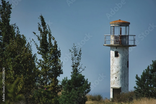 Fototapeta Weathered Neeme Lighthouse on Estonia's Coast, Standing Tall Against the Blue Sky