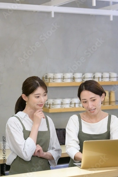 Obraz カフェの受付でパソコンを見て悩む日本人女性