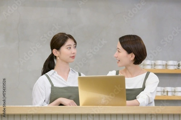 Obraz カフェの受付でパソコンを見て悩む日本人女性
