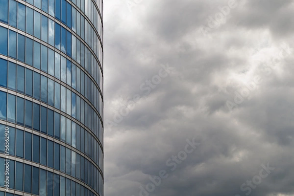 Fototapeta Modern glass office building facade with reflection of cloudy sky