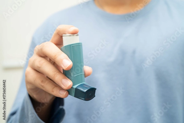 Fototapeta Asthma and chronic obstructive pulmonary disease COPD, Asian young man using metered dose inhaler MDI.