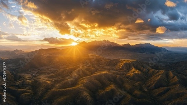 Fototapeta A view of a mountain range with a sunset