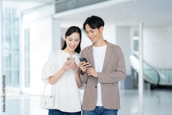 Obraz デート中にスマホを見る若いカップル