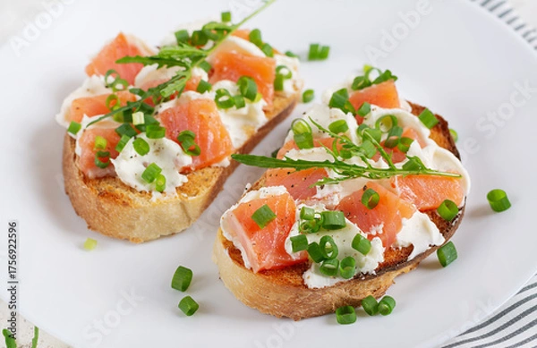 Obraz Two open sandwich, toast with salmon, cream cheese, green onions for healthy breakfast on white plate.