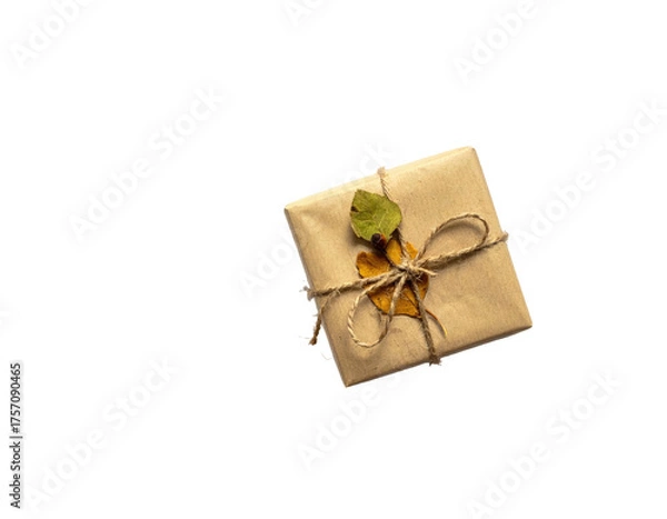 Obraz A beautifully wrapped gift with twine and autumn leaves on a stark, black background