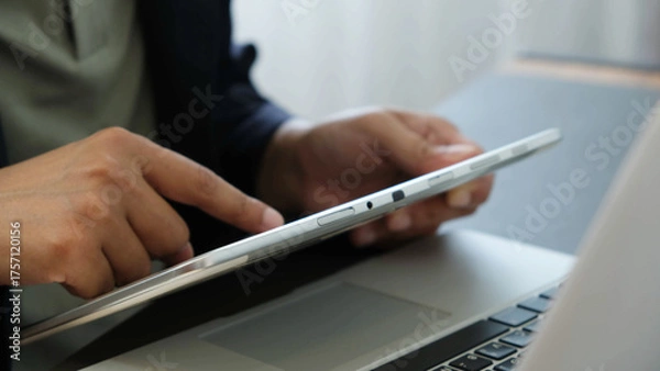 Fototapeta Businessman using digital tablet near laptop in office, focused on screen