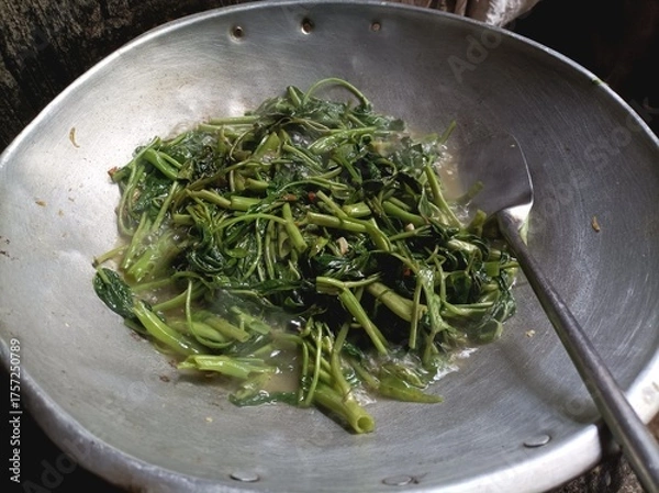 Fototapeta Stir-fried water spinach in a wok with garlic and chili.