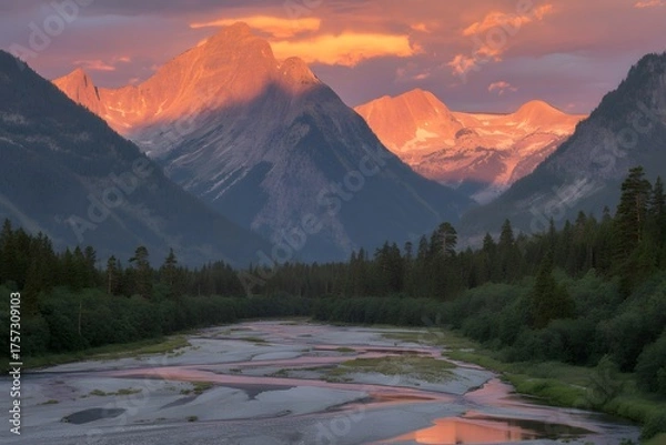 Fototapeta Majestic mountain peaks bathed in the warm vibrant hues of a breathtaking sunset reflected in a serene river below