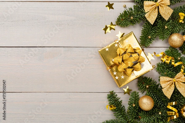 Fototapeta Festive Christmas tree branches with gift box on wooden background, top view