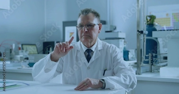 Obraz Scientist wearing lab coat pointing at periodic table on monitor in research lab, with gas cylinder