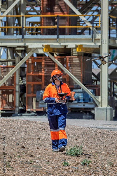 Fototapeta industrial drone pilot mapping and inspecting at a diamond mine metal structure from a plant