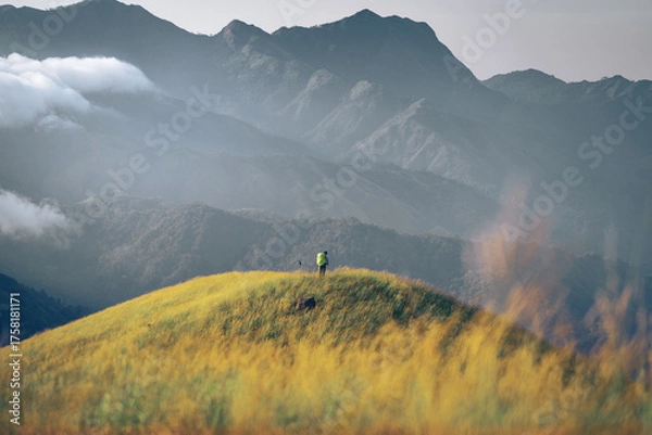 Fototapeta A man with his tent is taking a view of Mountain Range view point in Myanmar (Burma) with sea of cloud (Mulayit Taung) and sunrise