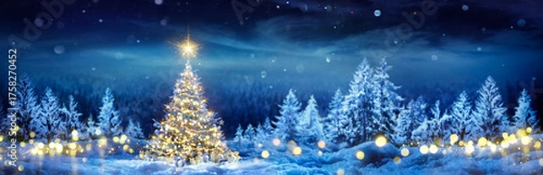 Fototapeta Christmas Tree On Snow - Winter Fir Forest At Night Forest - Pine Tree With Gift Boxes And With Shiny Star In Blue Landscape And Abstract Bokeh Lights