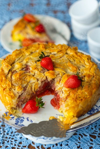 Obraz Piece of strawberry pie with lemon and fresh berries on lace light blue tablecloth