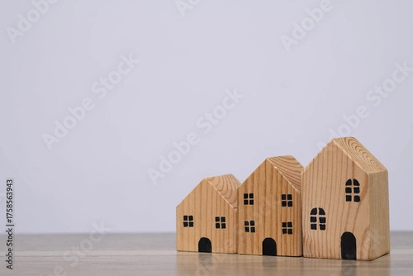 Obraz Wooden toy houses arranged by size on table symbolize property investment, real estate market growth, home buying, mortgage planning, and housing finance concepts.