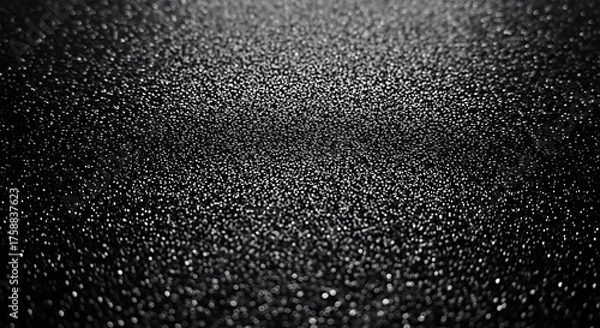 Fototapeta Close-up view of a textured surface, exhibiting a myriad of small, reflective specks against a deep black backdrop, creating a captivating visual effect.