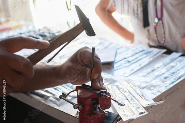 Fototapeta Close up of unrecognizable person holding a hammer and working with metal. Tunisia