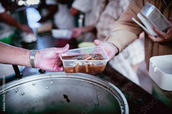 Fototapeta The hands of the hungry are asking for food from the donor