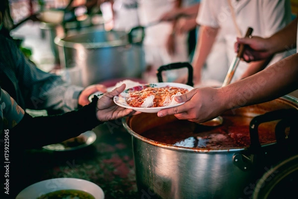 Fototapeta The hand of a beggar received food from a compassionate person, Concept of sharing