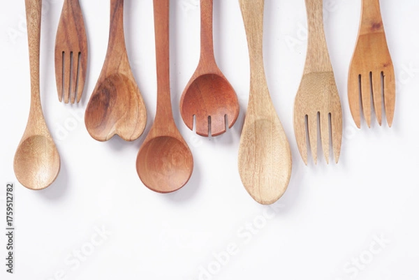 Fototapeta Wooden spoons and forks are stacked on a white background.
