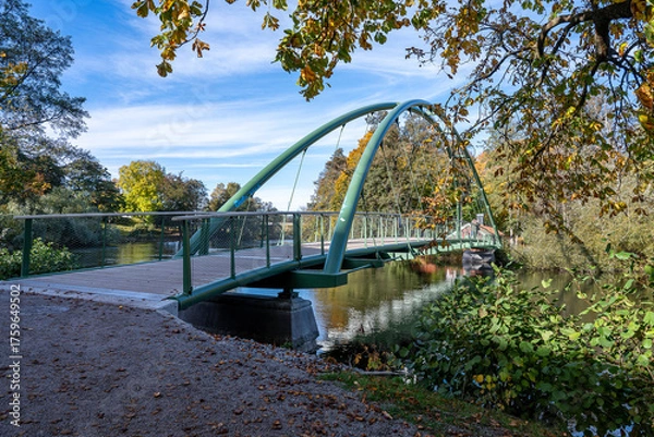 Fototapeta Bridge across Motala Stream connecting city park Åbackarn wirh Folkparken on a sunny autumn day in mid-October 2025 in Norrköping, Sweden
