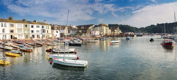 Fototapeta Panorama of the coast in the town of Teignmouth. Some people rest on the beach. Swim boats after a day's work.