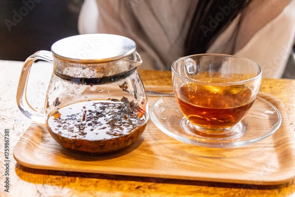 Fototapeta 茶葉が入ったガラス製ティーポットとカップに注がれた紅茶
