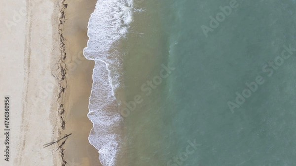 Fototapeta Beach top view of soft blue ocean wave on clean sandy beach and relaxing aerial scene, summer vacation holiday template banner. Waves surf with blue ocean lagoon