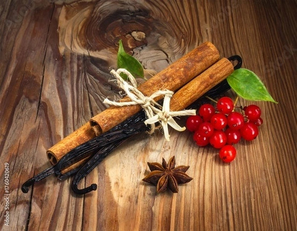 Fototapeta Still life of warm spices, berries, and beans on rustic wood